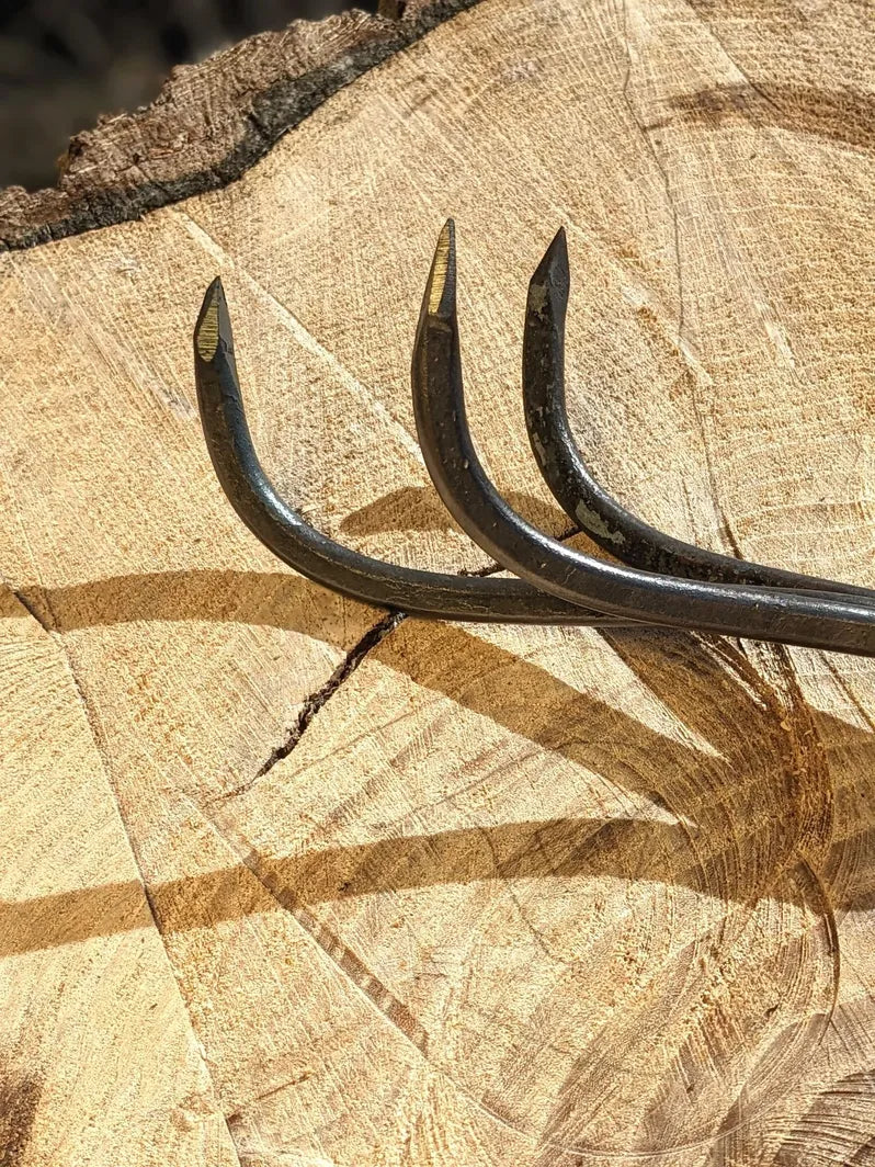 3 Tine Cultivator, Hand Forged Garden Tool, Lifetime Guarantee. Focus on tool head on wooden background