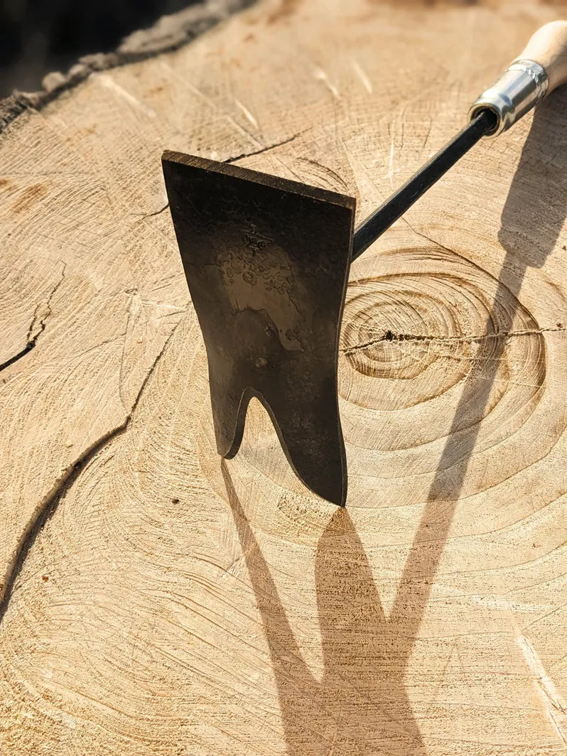 Grub Hoe, hand forged garden tool by Homestead Iron on wooden background.