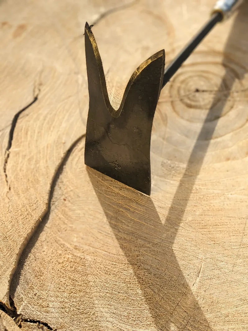 Grub Hoe, hand forged garden tool by Homestead Iron  on wooden background with deep shadows.