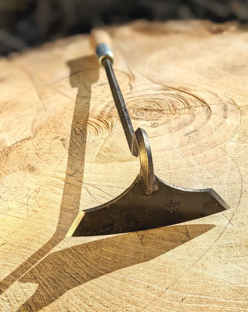 Batwing Hoe, Cotton Hoe Hand Forged Garden Tool by Homestead Iron on wooden background with child's drawing. 