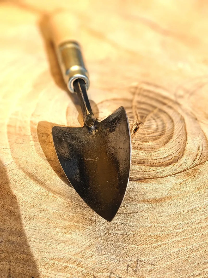 Small Trowel, Hand Forged Garden Tool Homestead Iron close up tool head on wooden background