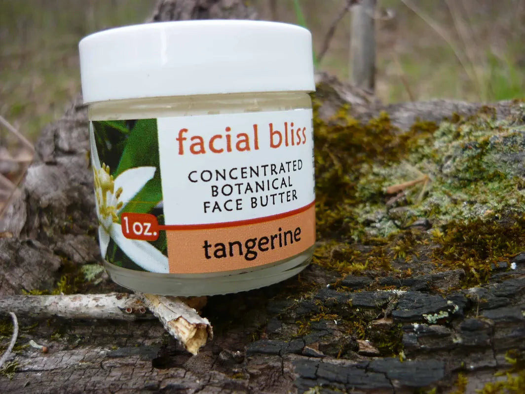 Tangerine botanical face moisturizer, face butter by Missouri Herbs nature on log. 