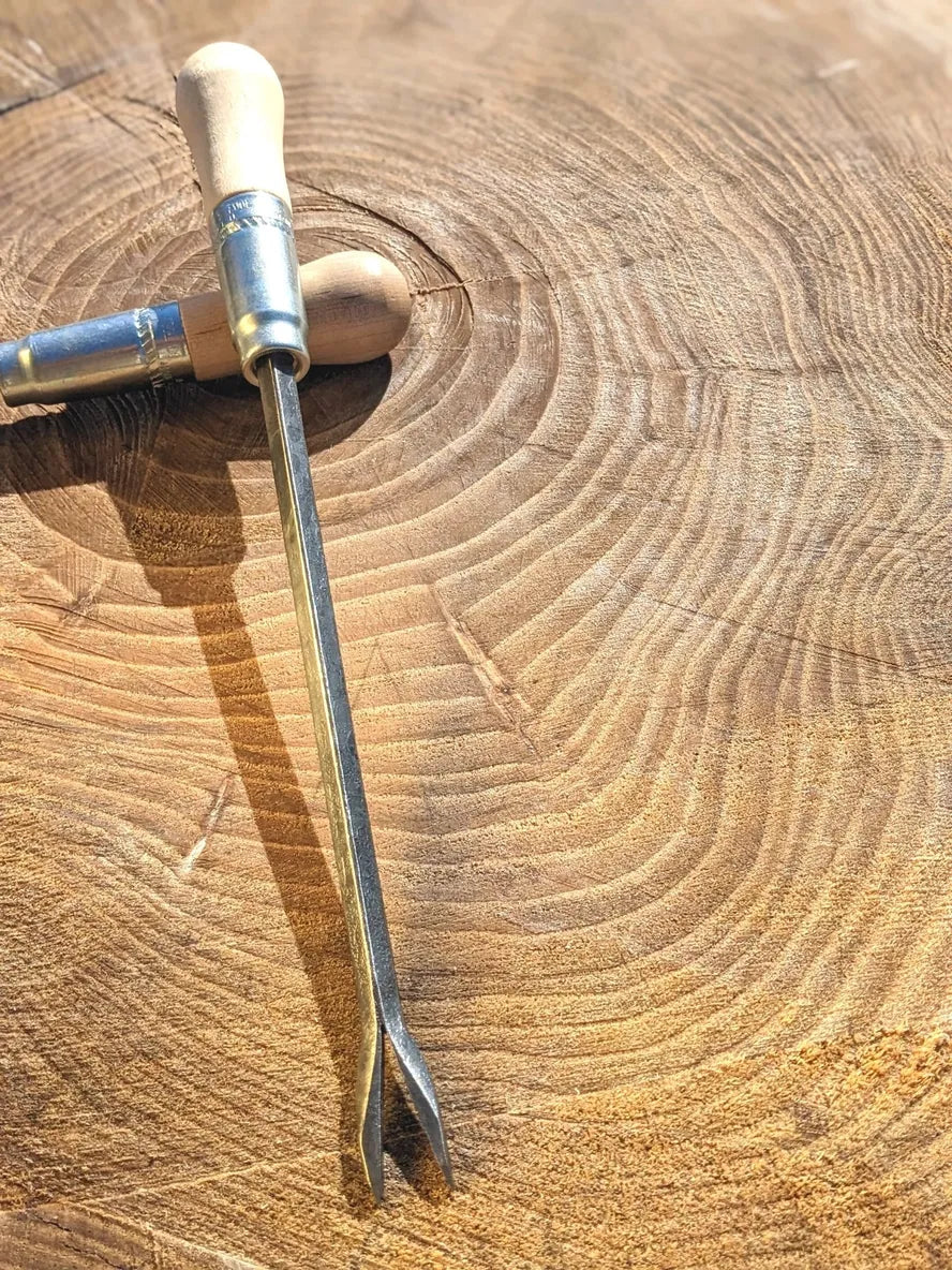 Weeding fork by Homestead Iron on wooden background. 