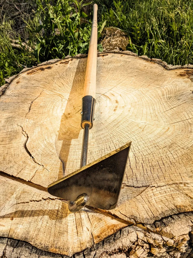 V-Hoe Aggressive Long Handled Hand Forged Hoe tool head pointed up on wood. 